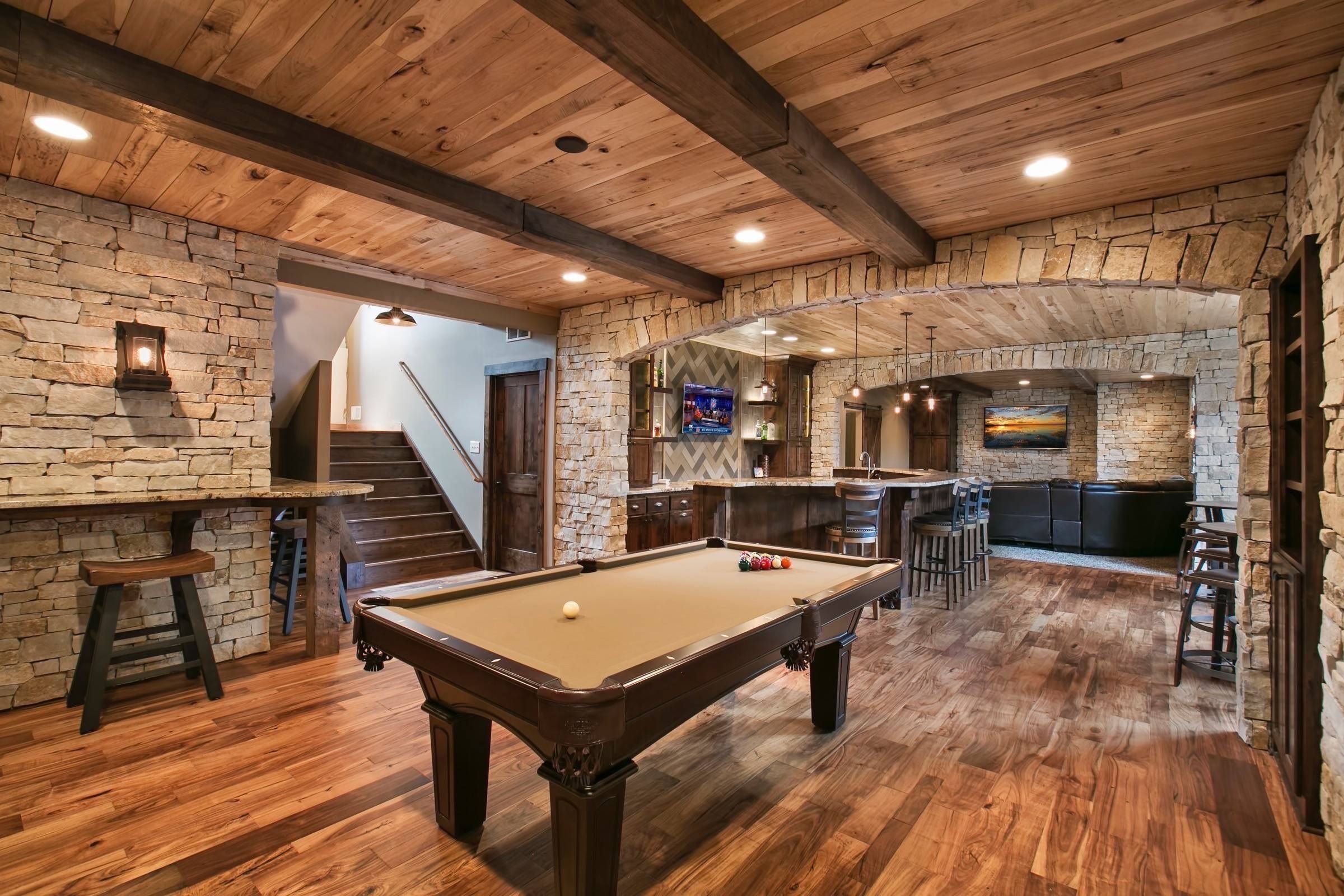 Rustic box beam ceiling accentuating a kitchen/bar basement space