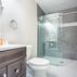 Basement Remodeling - Modern Bathroom With Grey Tile and Glass Shower Door 