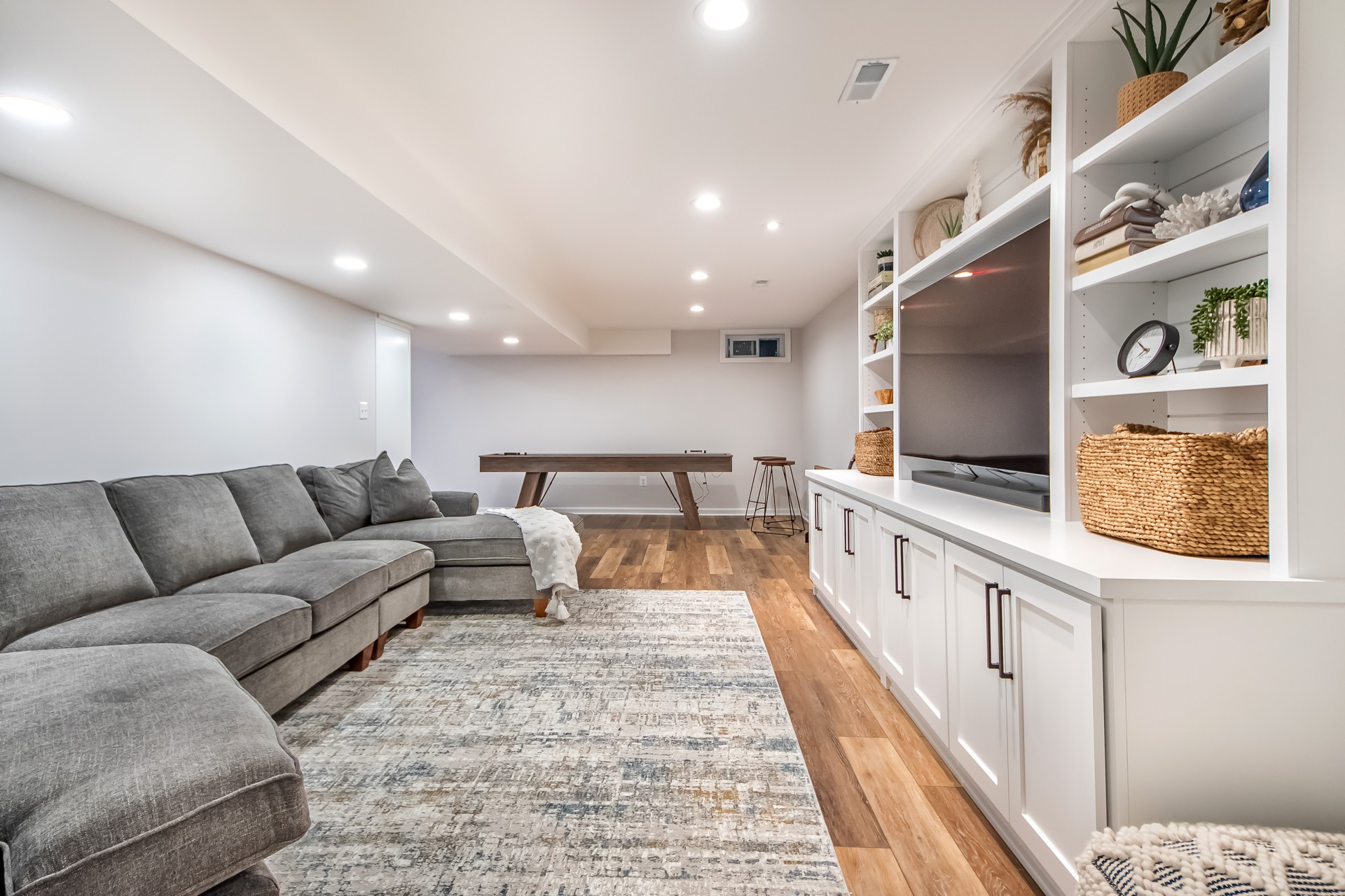 Welcoming basement finishing with beautiful built-ins and small wet-bar