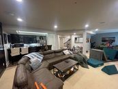 Sophisticated basement retreat with a marble-topped bar and a moody stone fireplace in Lutherville, MD