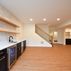 A 1,336 sq. ft. basement renovation with a stacked-stone fireplace, custom wet bar, and private suite, Fairfax, VA